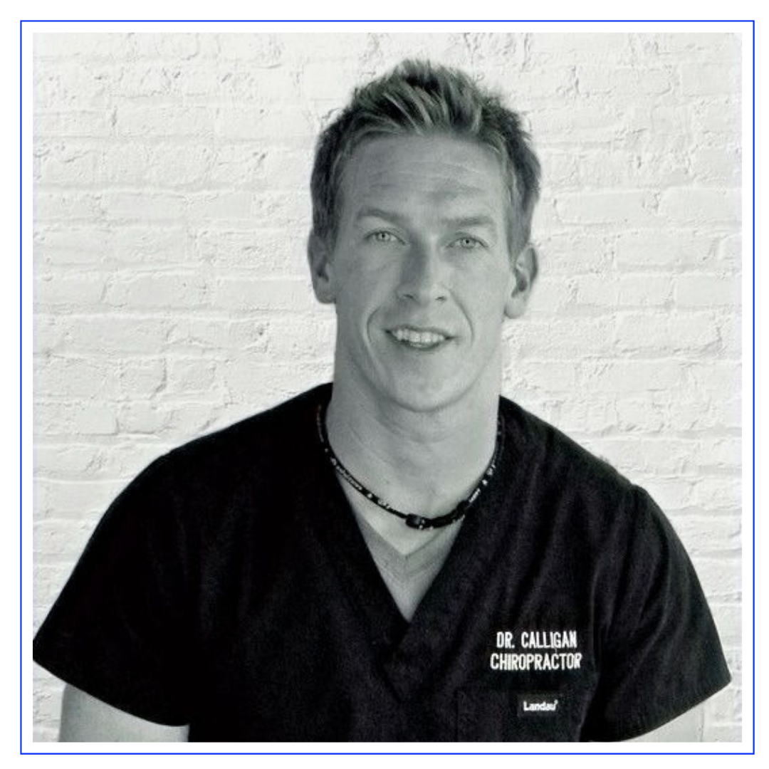 A man wearing a chiropractor uniform is smiling at the camera. The image is in black and white, with a white brick wall in the background. The text on his shirt reads "Dr. Calligan Chiropractor."